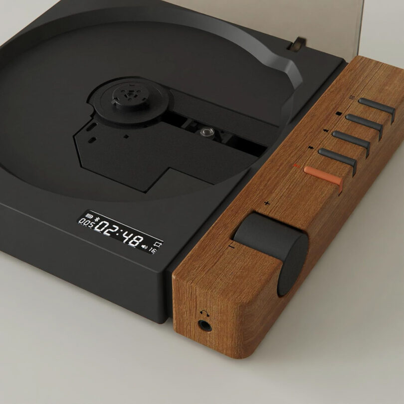 The Syitren R300 is a modern turntable featuring a digital display, elegant wooden accents, intuitive control buttons, and a convenient headphone jack.