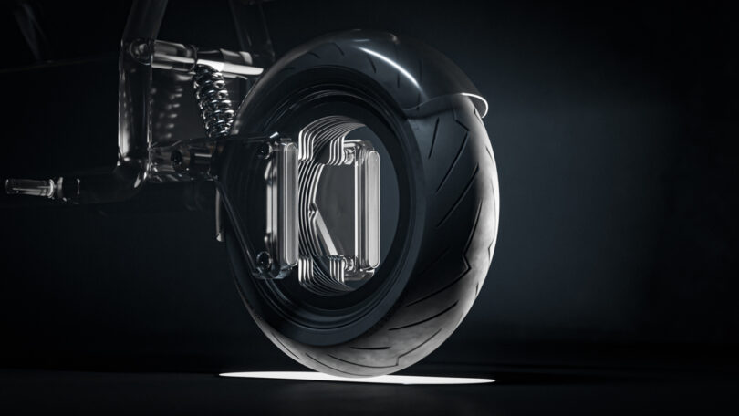 Close-up of a motorcycle wheel with a modern suspension and a transparent, futuristic hub set against a dark background.