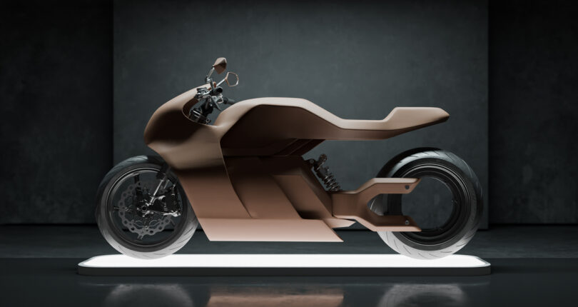 A matte brown, futuristic, concept motorcycle with a minimalist design is displayed on a lit platform against a dark background.