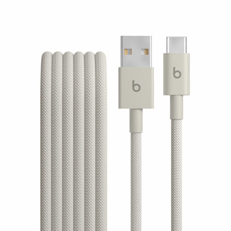 Coiled gray braided charging cable with USB-A connector on one end and USB-C connector on the other, both labeled with a "b" Beats logo.