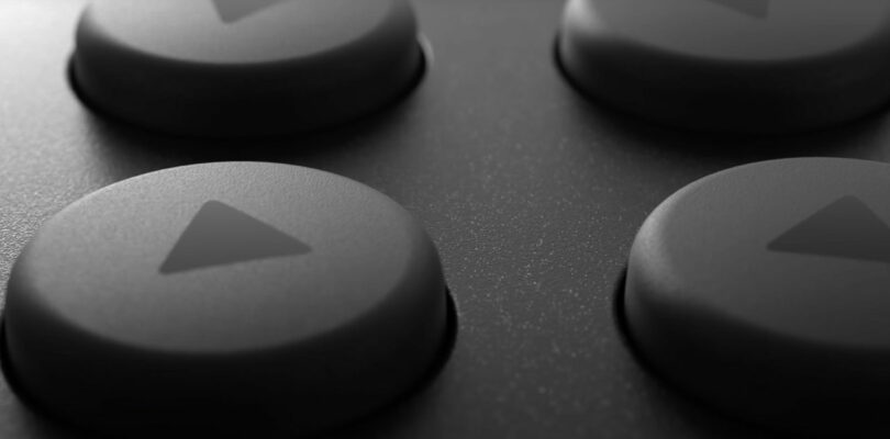 Close-up of four round, textured buttons with triangular arrows on a dark surface, resembling a directional pad on a Switch 2 gaming controller.