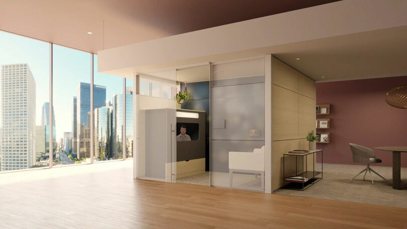 Modern office space with floor-to-ceiling windows offers an impressive ocular view, featuring a small glass-walled room with a desk and chair, and city skyscrapers visible outside.