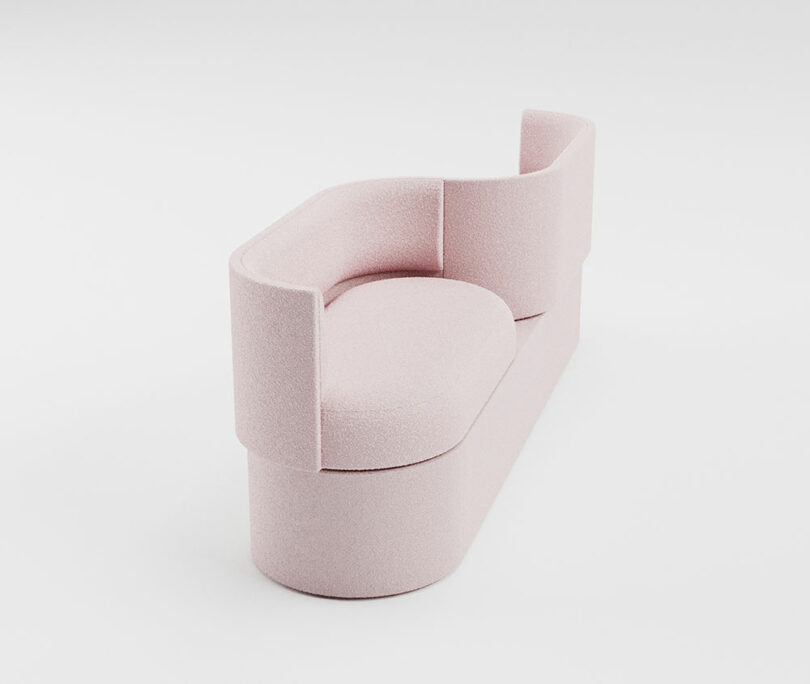 A modern, pale pink upholstered sofa with a curved backrest and a geometric, minimalist design set against a white background.
