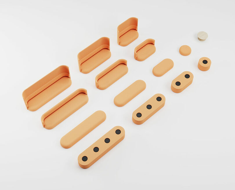 A set of orange, rectangular and circular objects arranged in rows on a white surface, some with black dots and others with smooth surfaces.