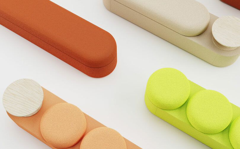 Rectangular and cylindrical objects in orange, beige, and green with round wooden and fabric elements arranged on a white surface.