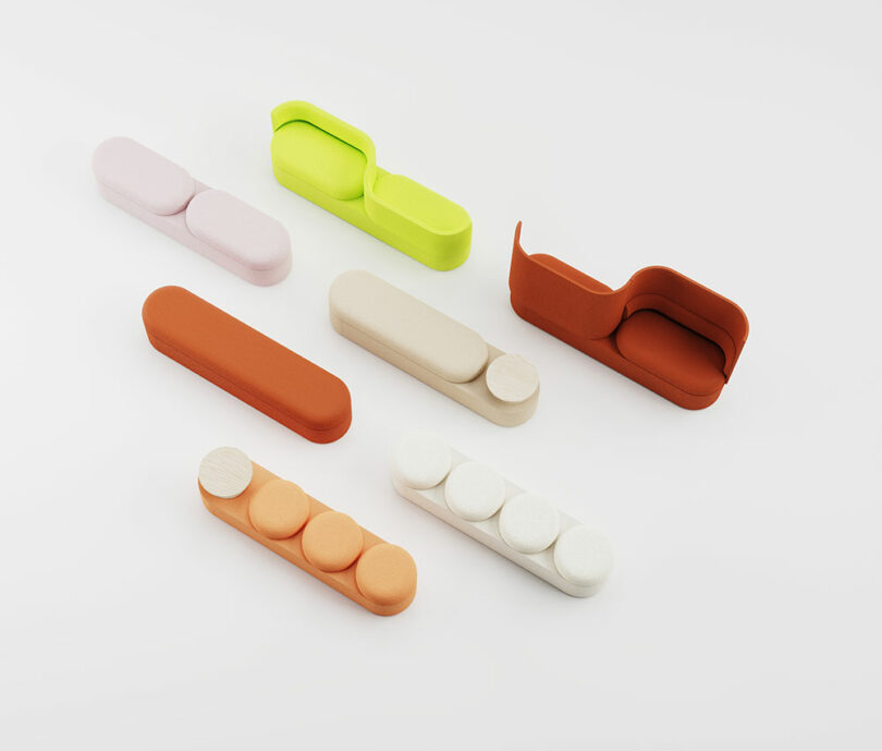 Seven colorful, minimalist sofa models are arranged on a white background, each with a unique geometric design and varying seat shapes.
