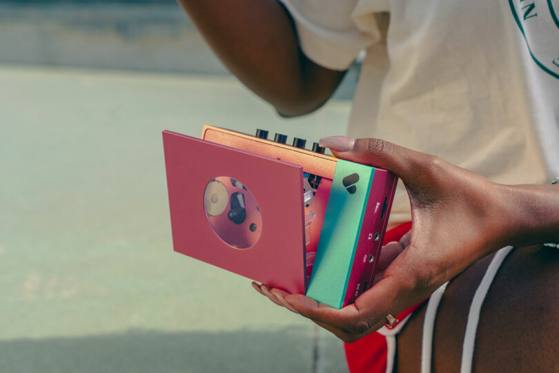 A person holds a colorful WE-001 Edith portable cassette player with visible buttons and a cassette tape inside.
