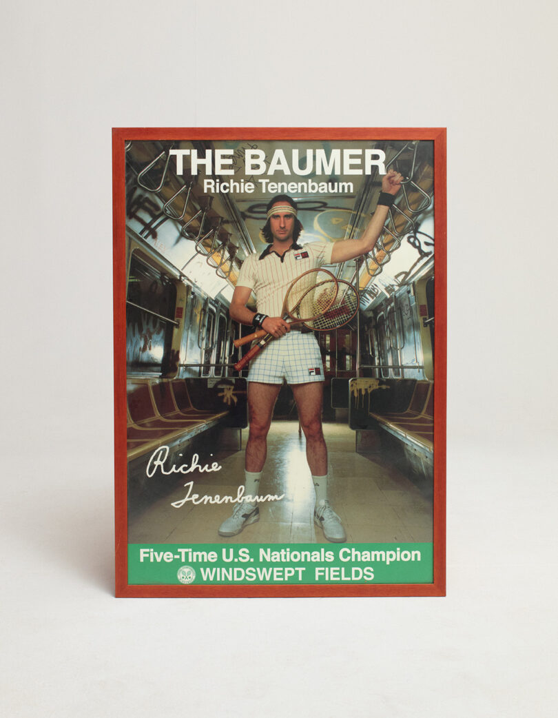 Framed poster of Richie Tenenbaum in tennis attire holding two racquets, titled "The Baumer," with text noting him as a five-time U.S. Nationals Champion at Windswept Fields.