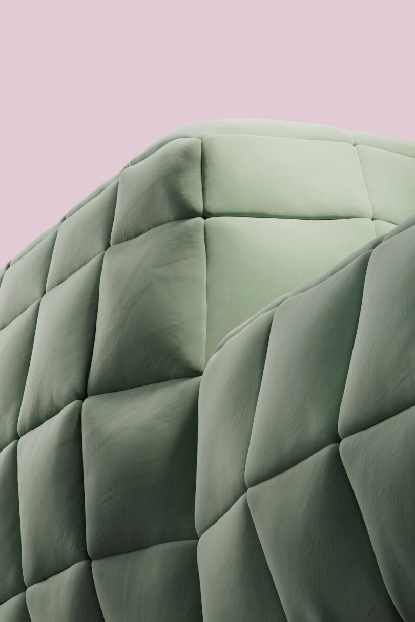 Close-up of a quilted surface with a soft, cushioned texture in a muted green color, set against a pale pink background.