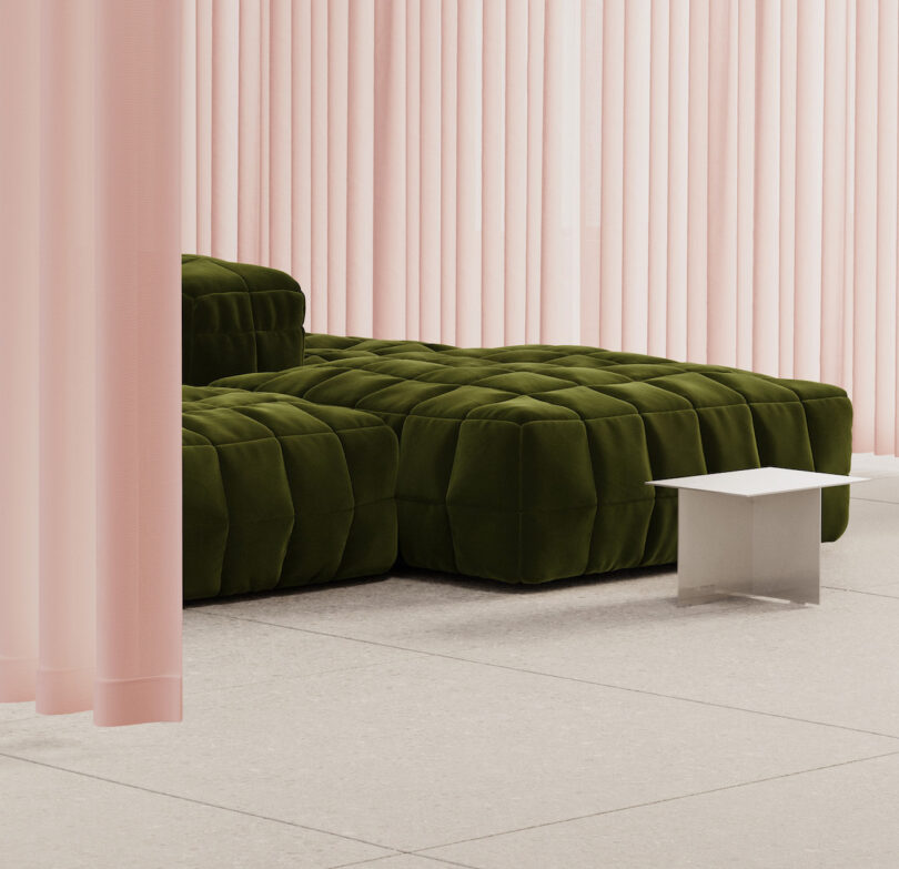 A modern room with pale pink curtains, a green tufted modular sofa, a small silver metal side table, and light-colored tile flooring