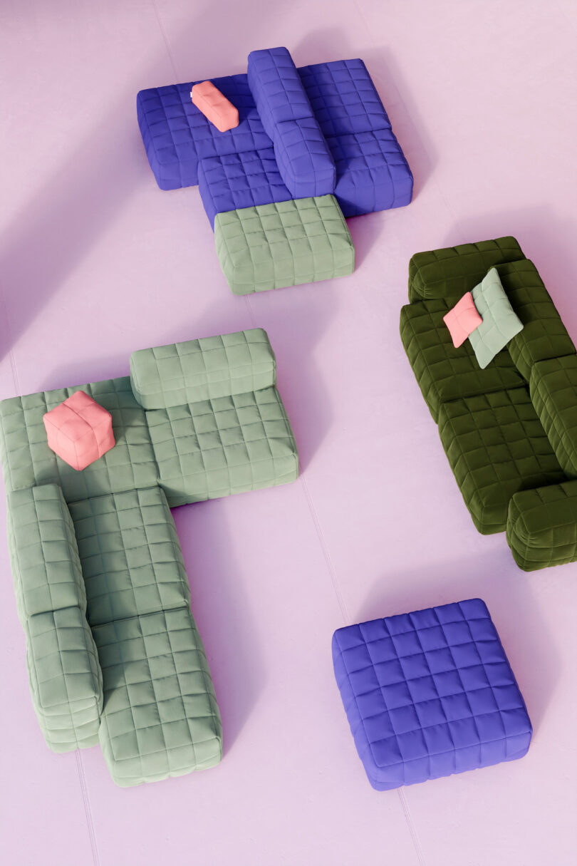 Three sets of quilted, modular sofas in blue, green, and olive are arranged on a light pink floor, each with matching square ottomans and cushions