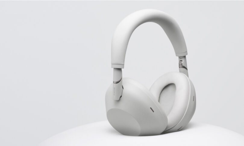 A pair of over-ear WH-1000XM6 wireless headphones in a light gray color is displayed on a white surface against a plain background.