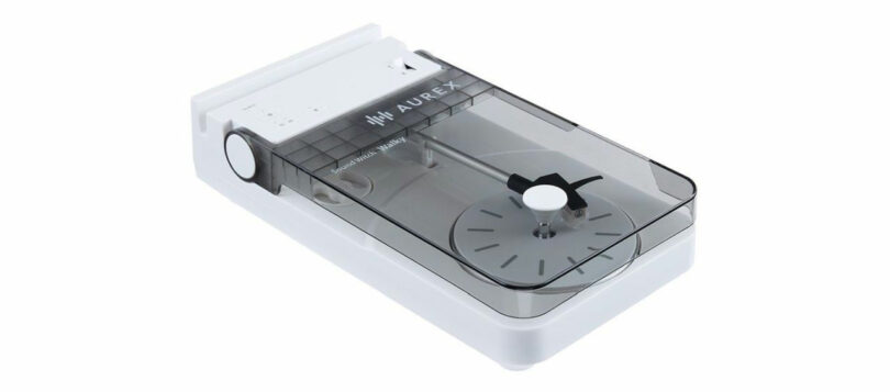 A white Aurex AX-RP10 record cleaner with a transparent lid, revealing internal cleaning components and a rotary dial on the side.