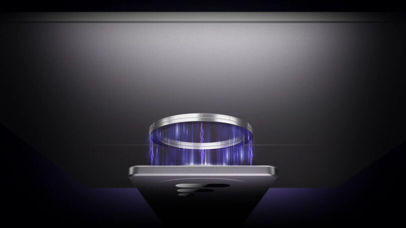 A close-up view of a smartphone charging wirelessly under a metallic charging pad, with blue energy lines illustrating the charging process.
