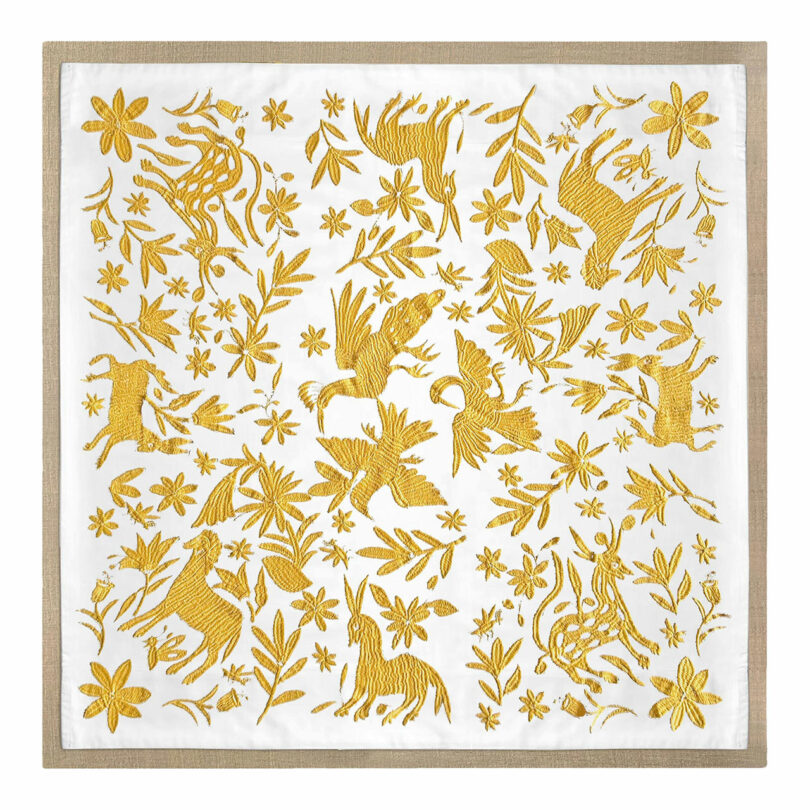 Square cloth with yellow embroidery by Sam Sacks, depicting birds, deer, rabbits, and floral motifs on a white background, bordered by a thin beige edge.