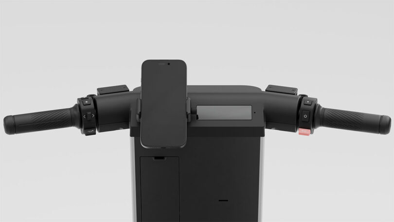 Close-up view of electric scooter handlebars with a smartphone mounted in the center, various control buttons, and a digital display, all against a plain background.