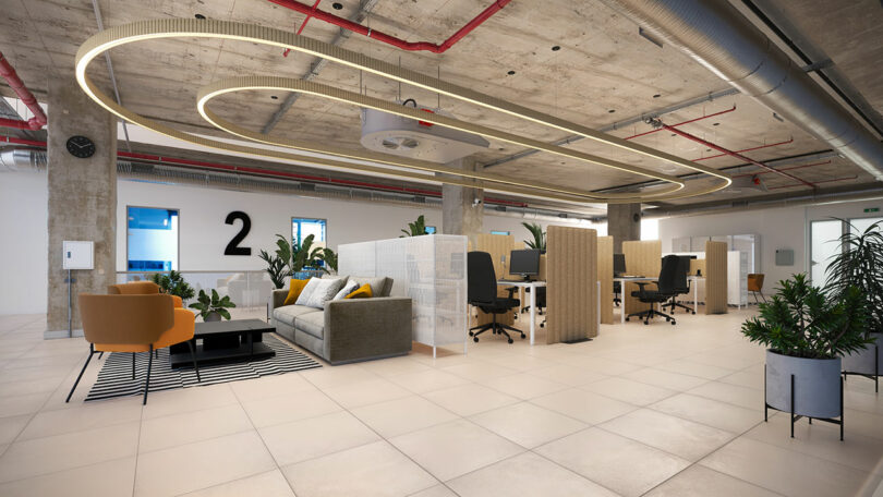Modern open-plan office with sofas, workstations, plants, and concrete ceiling featuring exposed pipes and circular LED lighting.