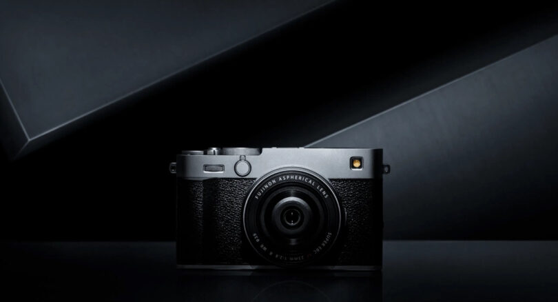 A Fujifilm X-E5 digital camera with a textured grip and prominent lens is centered against a dark, minimalistic background with geometric lines.