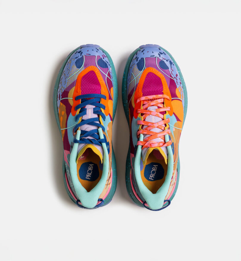 A pair of brightly colored athletic shoes with mismatched designs, viewed from above on a white background