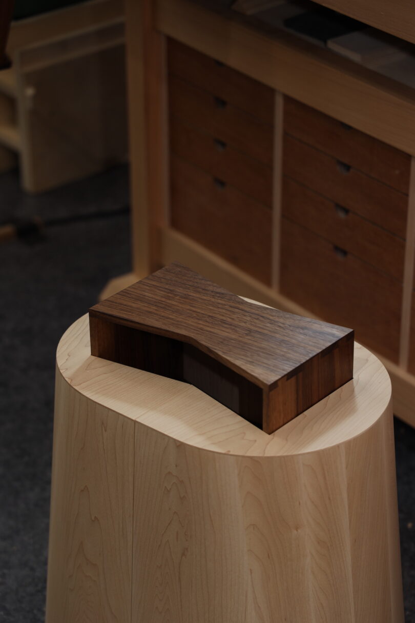 an oval stool with a shelf embedded into the seat