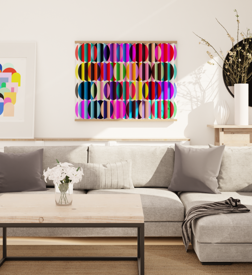 A modern living room with a gray sectional sofa, a wooden coffee table, and colorful geometric artwork on the wall above the sofa