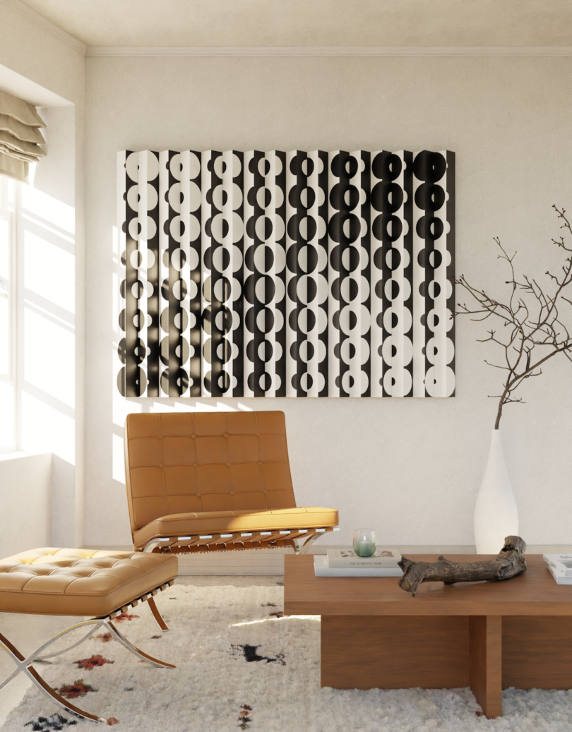 A modern living room with a tan leather chair and ottoman, a wooden coffee table, a large geometric black-and-white wall art, and a tall vase with branches