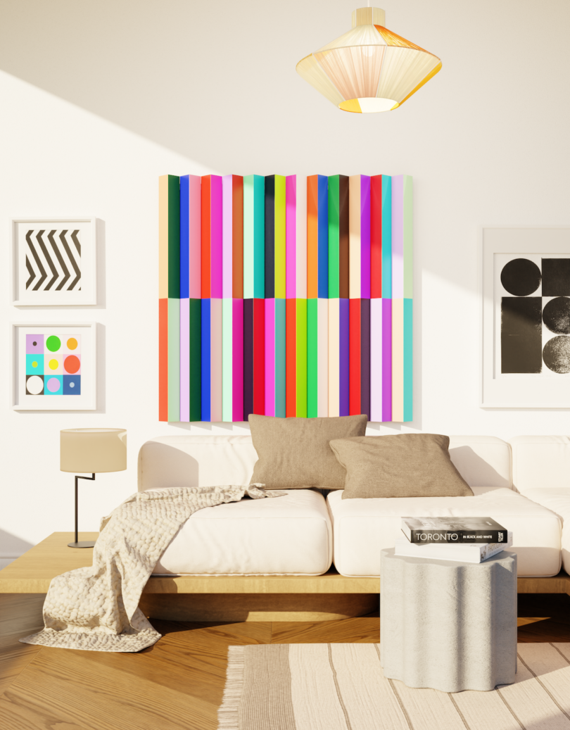 A modern living room with a white sofa, neutral cushions, a throw blanket, a round ottoman, and colorful geometric wall art in a bright, sunlit space