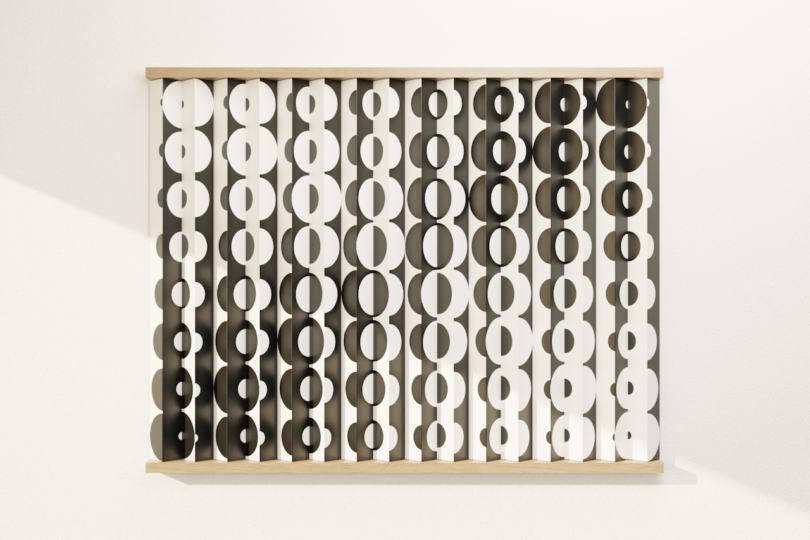 Wall-mounted artwork featuring vertical slats with alternating black and white oval patterns, creating an optical illusion effect against a white background