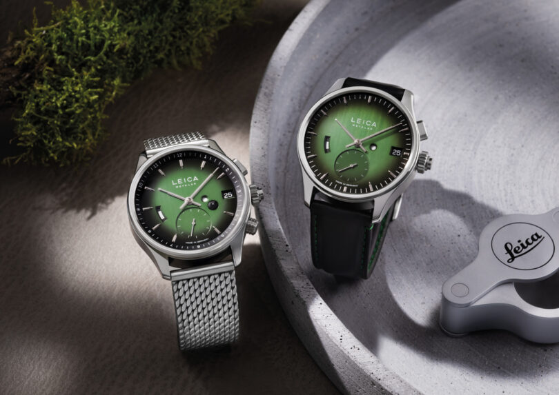 Es werden zwei Leica -Uhr mit grünen Zifferblättern angezeigt. Einer ist mit einem Metallgürtel aus Netz, der andere ein schwarzes Lederband. Die inspirierte Fotografie wird der stilvollen Szene hinzugefügt.