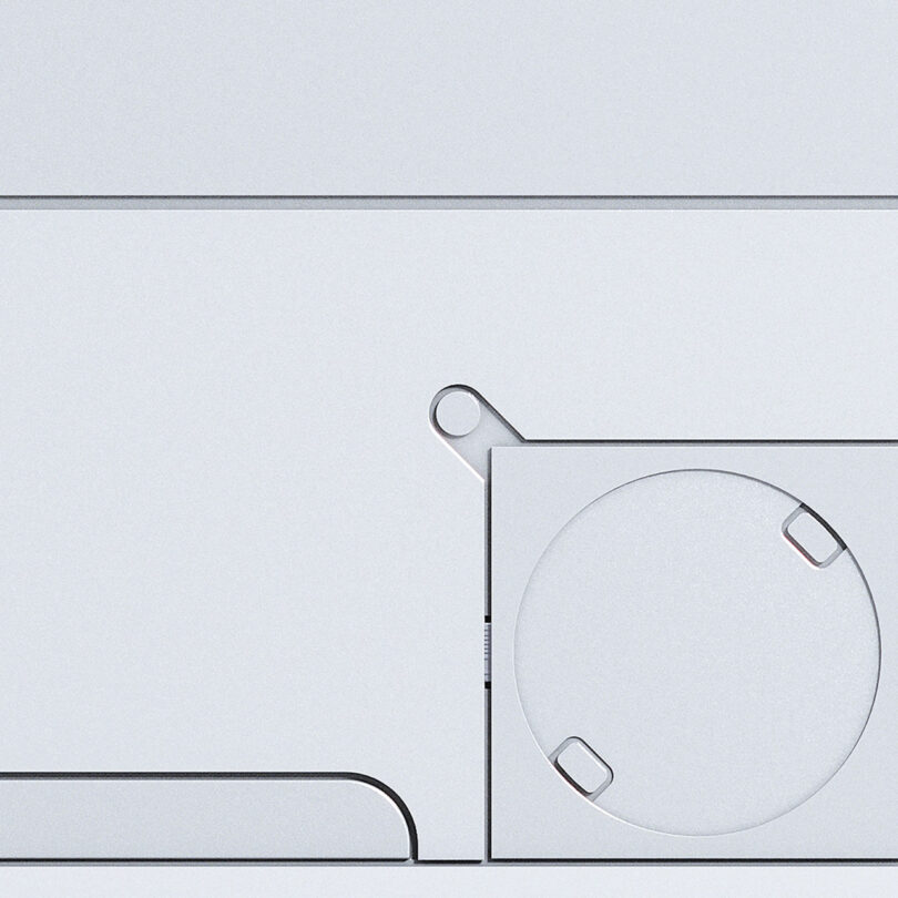 Close-up view of a minimalistic, modern white Nothing surface featuring geometric shapes, including a square with a large circular indentation and small rectangular cutouts.