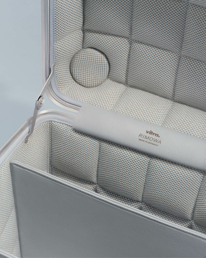 Open suitcase with a quilted, textured interior, featuring a silver handle 