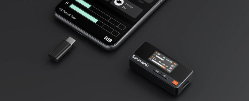 A Saramonic Air wireless microphone receiver, a USB-C adapter, and a smartphone displaying audio settings are arranged on a dark surface.