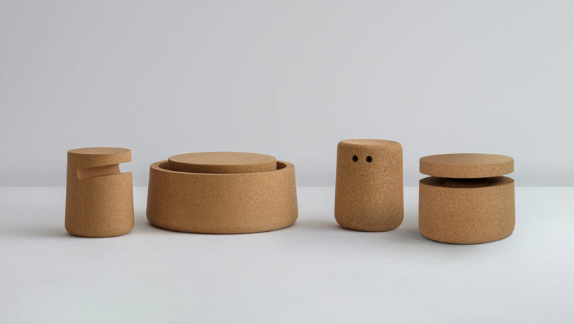 Four minimalist cork stools and tables of varying shapes and sizes are arranged in a row against a plain, light background.