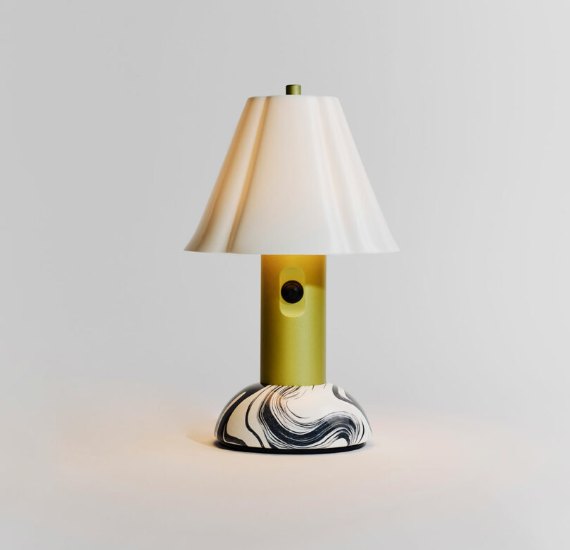 A modern table lamp with a white conical shade, olive green cylindrical base, and a round marble-patterned bottom, set against a plain light background.