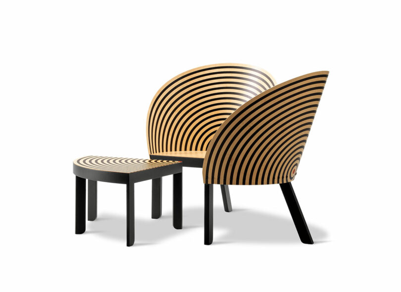 Two modern wooden chairs with black spiral patterns on the seats and backs, set side by side like a stylish bench for two, against a plain white background.