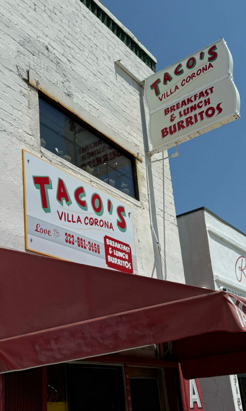 A white building with signs for Taco's Villa Corona, advertising breakfast, lunch, and burritos above a red awning, is featured in this David Kaul photograph.