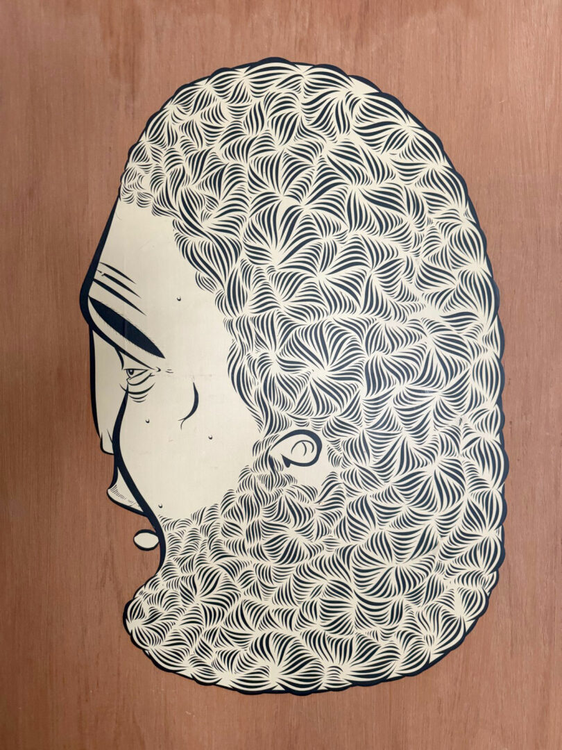 A stylized side profile illustration of a face with intricate, wave-like patterns forming the hair and beard, set against a wooden background—a signature work from artist David Kaul.