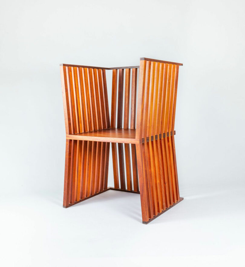 Wooden chair with vertical slats forming the sides, backrest, and legs, creating a geometric, modern design against a plain white background.