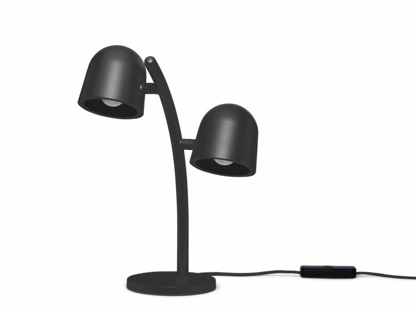 A black, double-headed desk lamp with a curved stand, round base, and power cord with an inline switch, set against a white background.