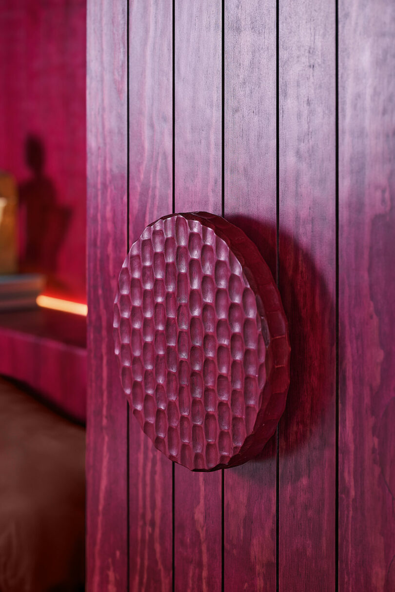 The textured, circular maronic handle was mounted on the vertical match of MAROON WOOD.