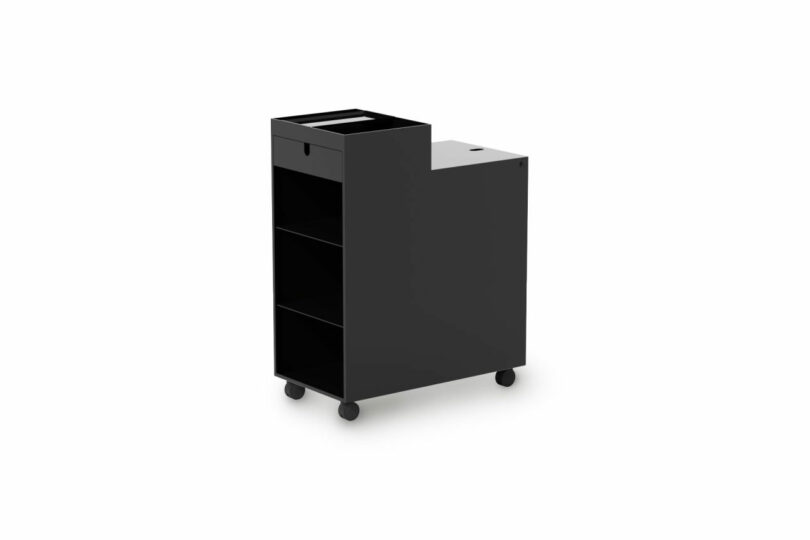 A black rolling storage cart with three open shelves, a drawer, and a flat top surface, set against a white background.