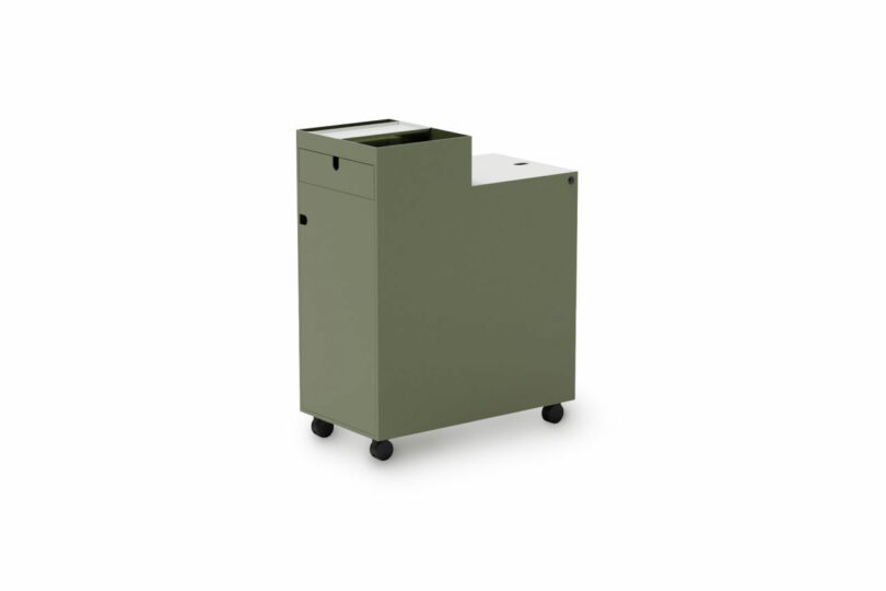 A green metal storage cart with one drawer and a top compartment, featuring four wheels for mobility, shown against a white background.