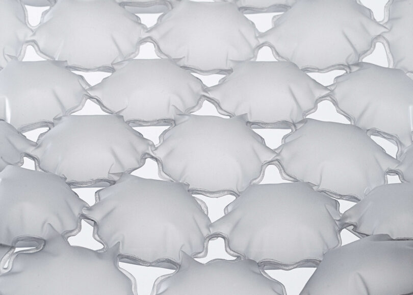 Close-up of an array of translucent, square-shaped inflated plastic pockets arranged in a grid pattern against a white background.