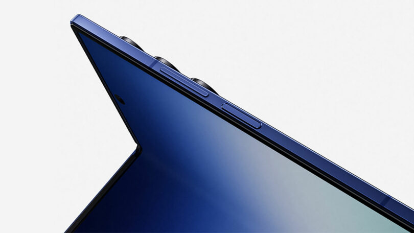 Close-up of the top edge of a blue Samsung smartphone showing volume buttons and rear camera lenses against a plain background.