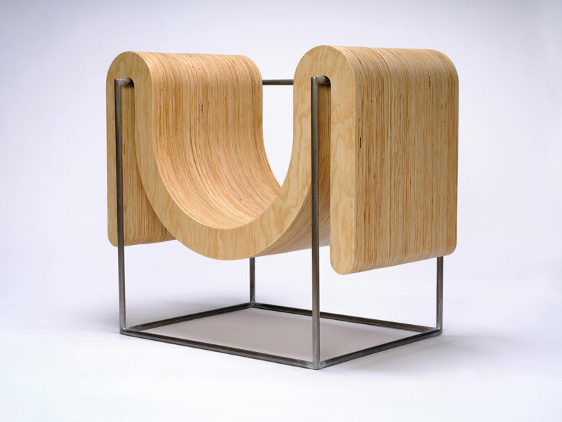 A modern chair with curved, laminated wood forming a U-shape, supported by a minimalistic metal frame.