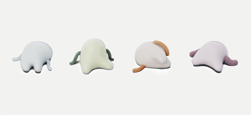 Four abstract, blob-shaped objects with short, textured appendages are arranged in a row against a plain white background.