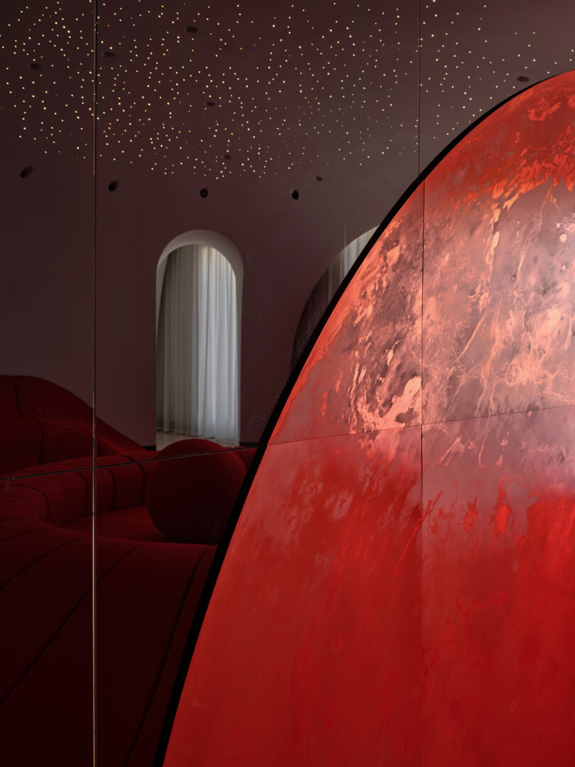 A red and black room with a red wall and a red couch.