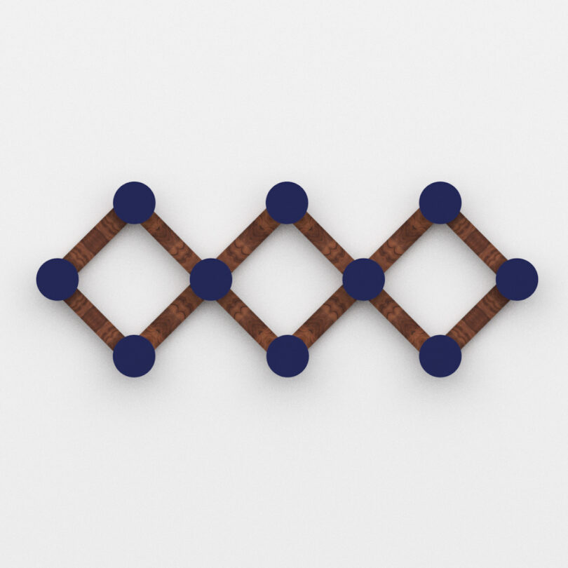 A geometric wall hook of two interlocking diamond shapes made of brown rods with blue circular nodes at the corners, set against a white background.