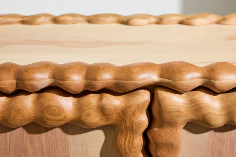 close up of A wooden cabinet featuring wavy, sculpted edges