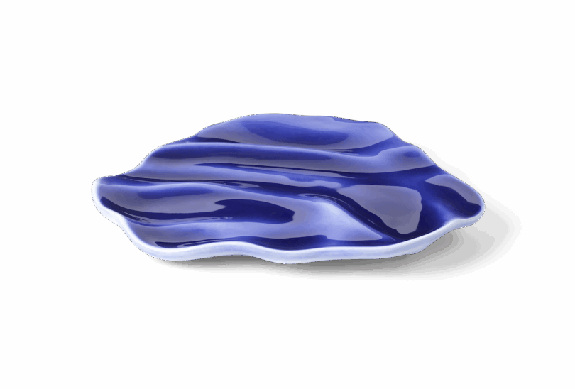 A blue and white ceramic dish with an irregular, wavy shape and a glossy finish.